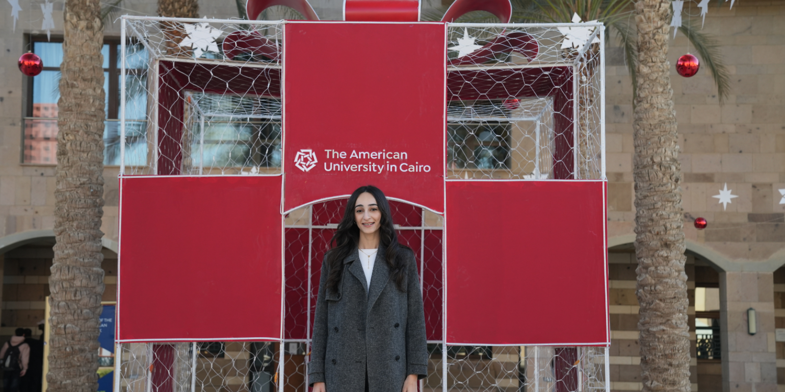 Monica Magdy stands in front of a wire gift box