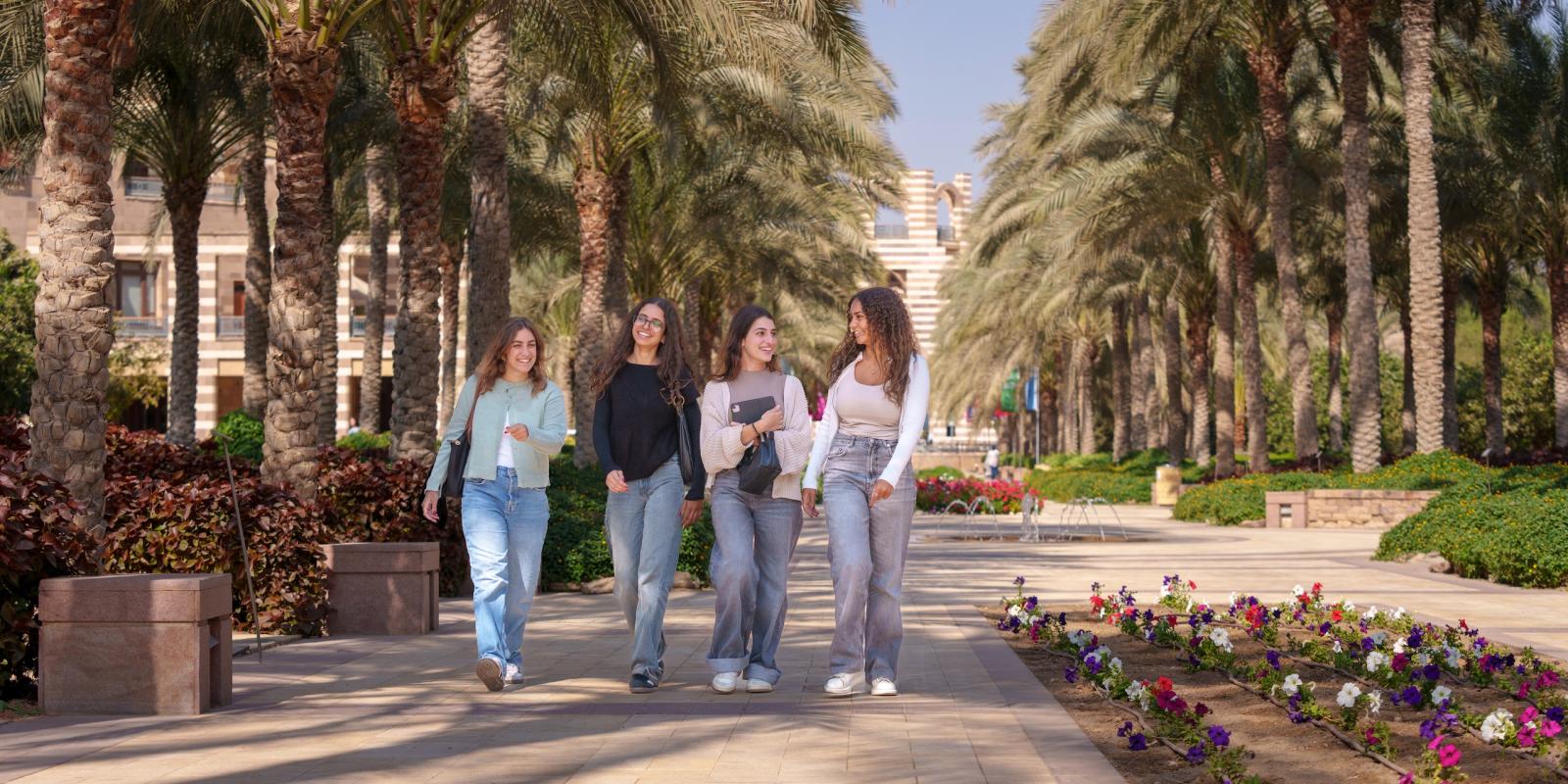 four girls walking together on campus