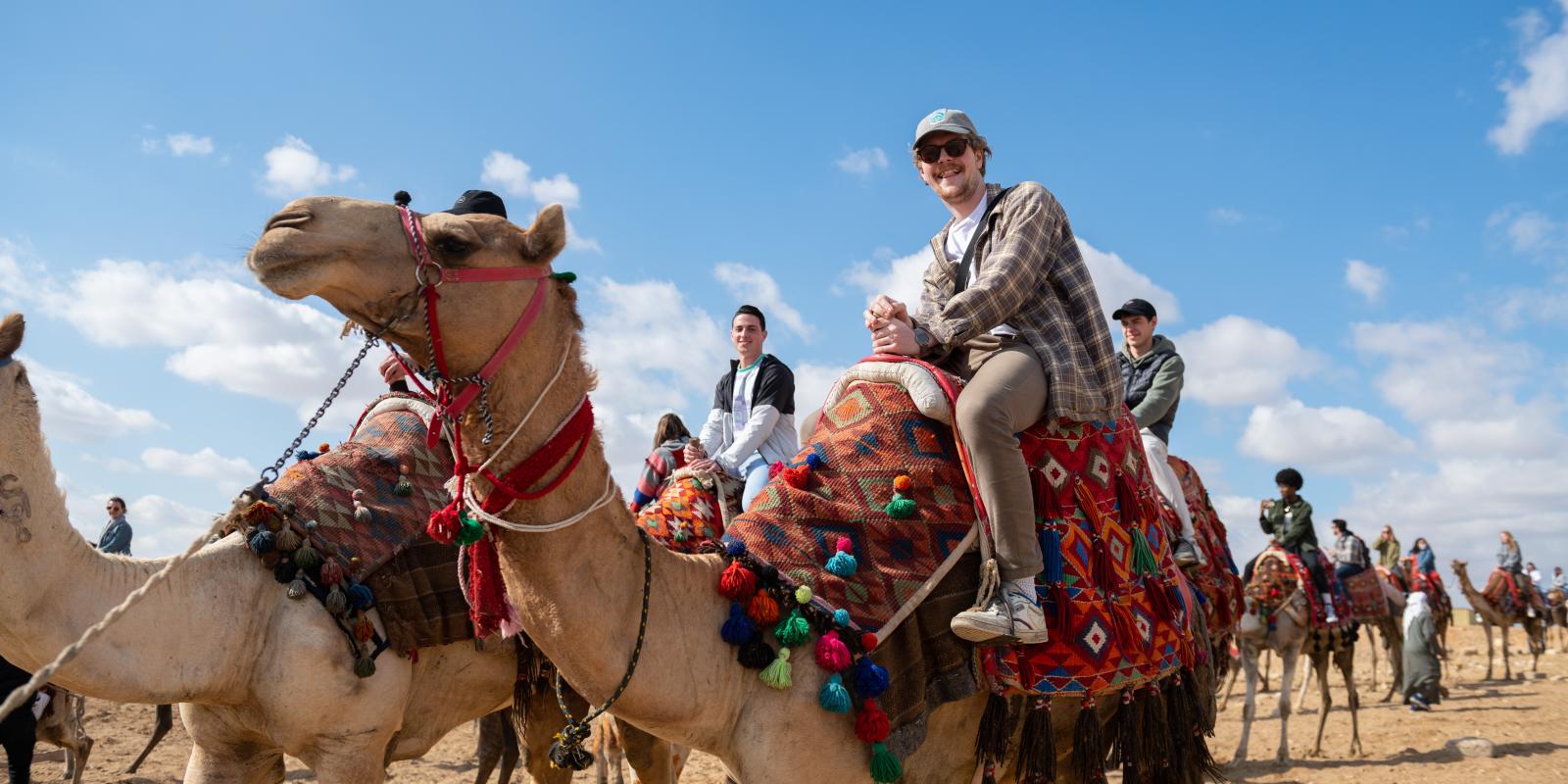 an international student riding a camel