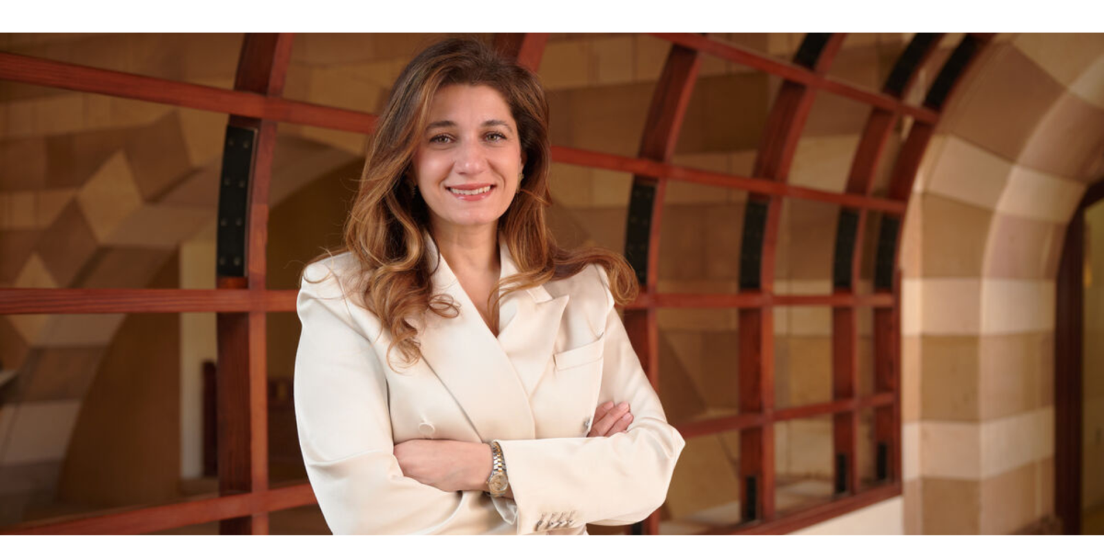 Farah Kashlan stands with her arms crossed in a hallway