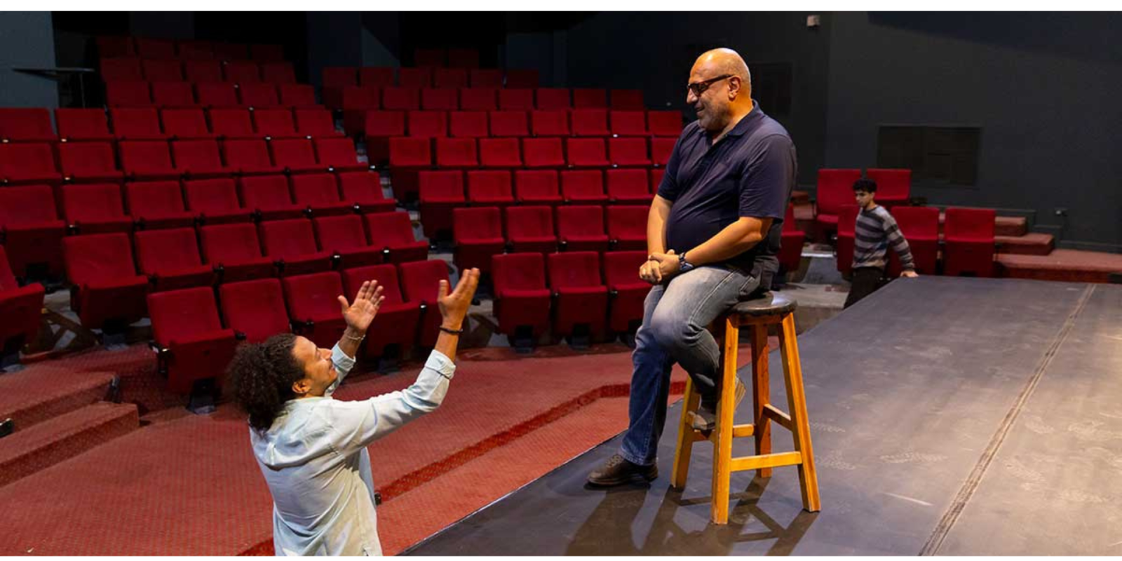 in the theater, an actor emoting to the director