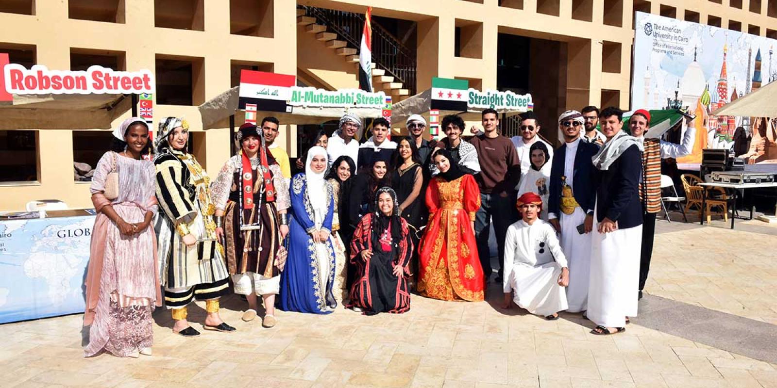 A group of students in various cultural dresses pose for a photo