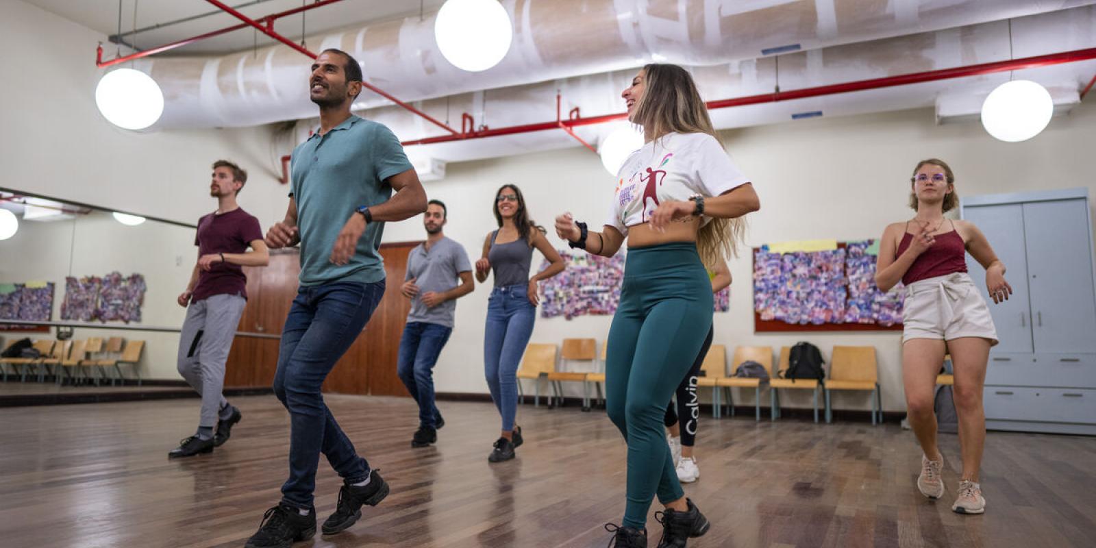 inside sports complex studio where students are in fitness dance class