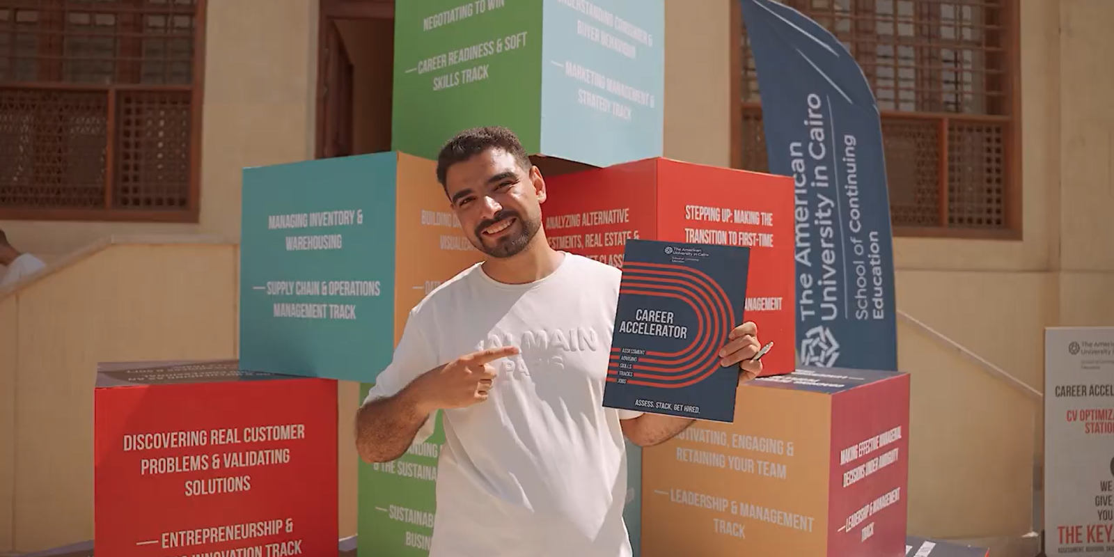 A person in front of a pyramid of cubes with text on their sides, points to a folder that says career accelerator