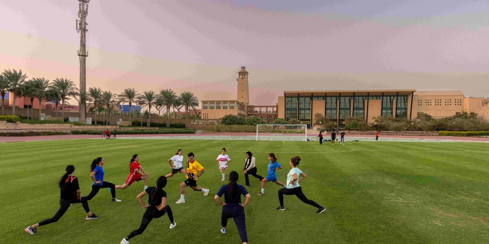 Athletes warming up in the Habtoor Stadium at AUC 