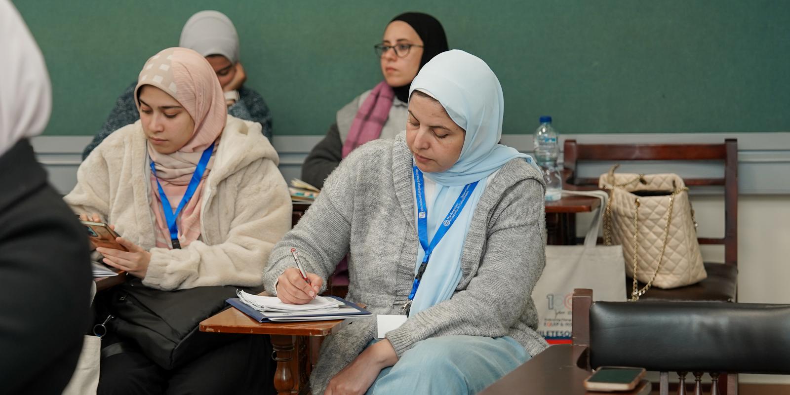 two veiled female students sitting in a classroom