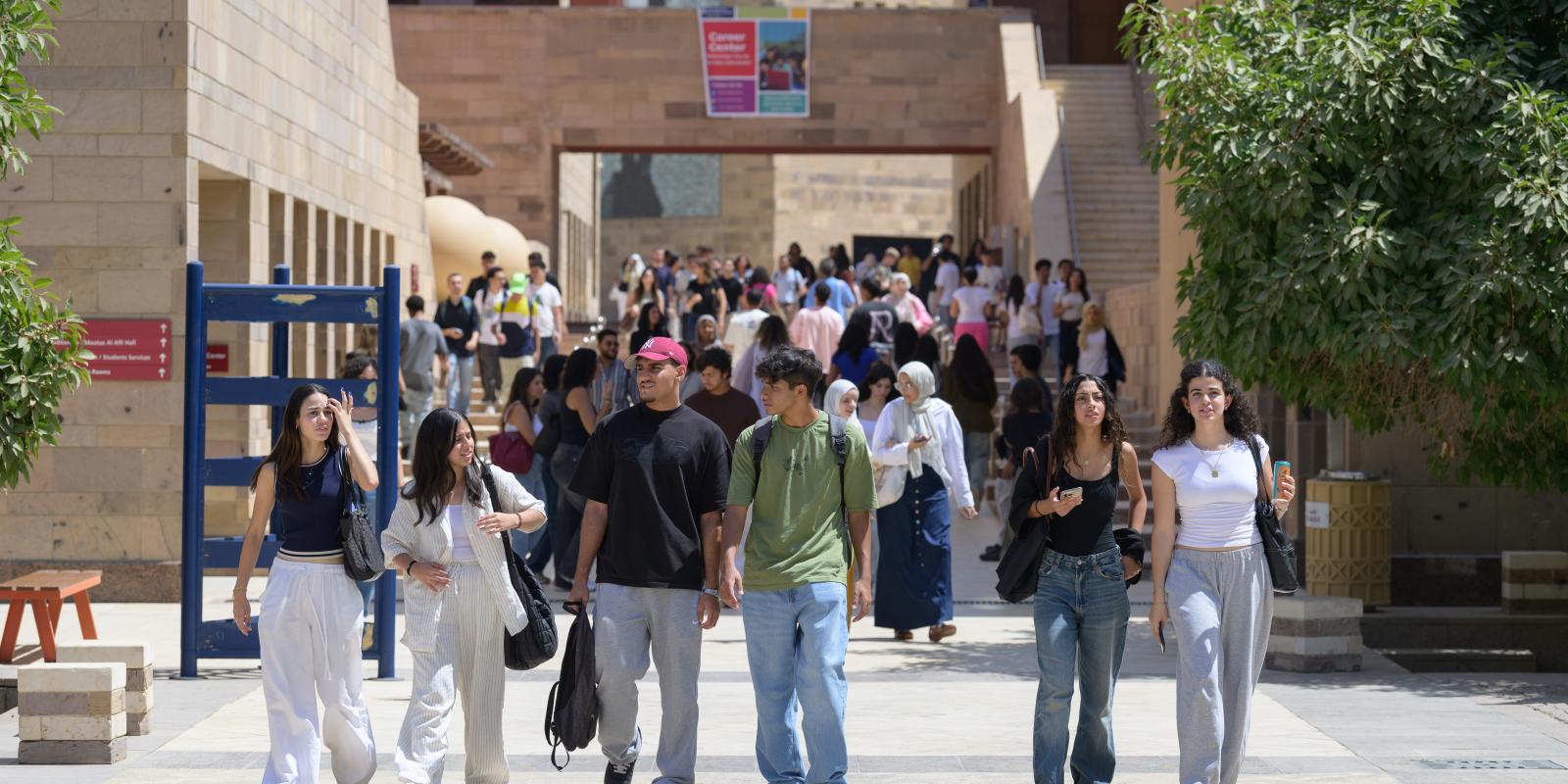 Students walk in a line on campus. 