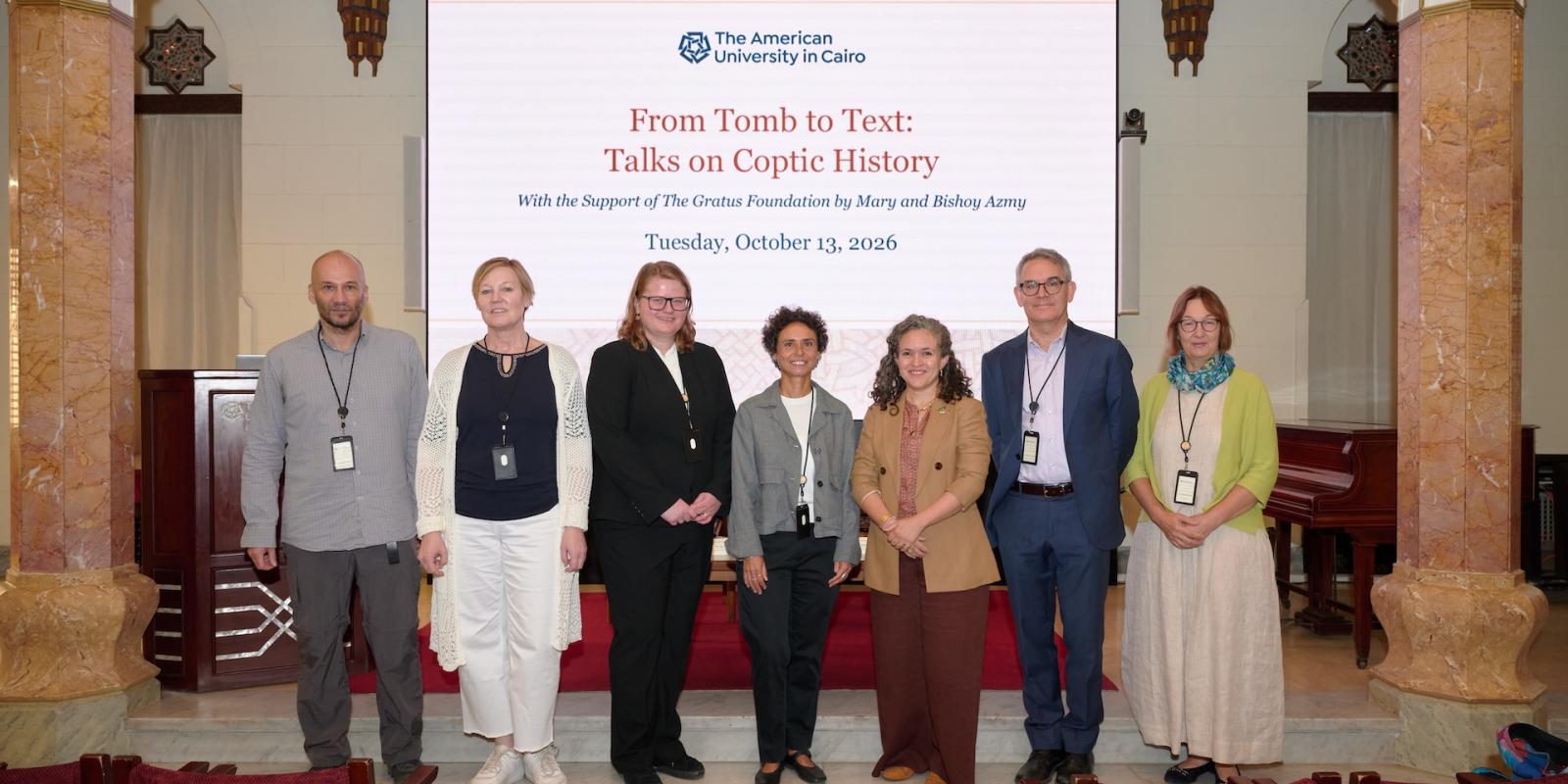 Speakers of the conference standing in front of the backdrop of the conference in Oriental Hall