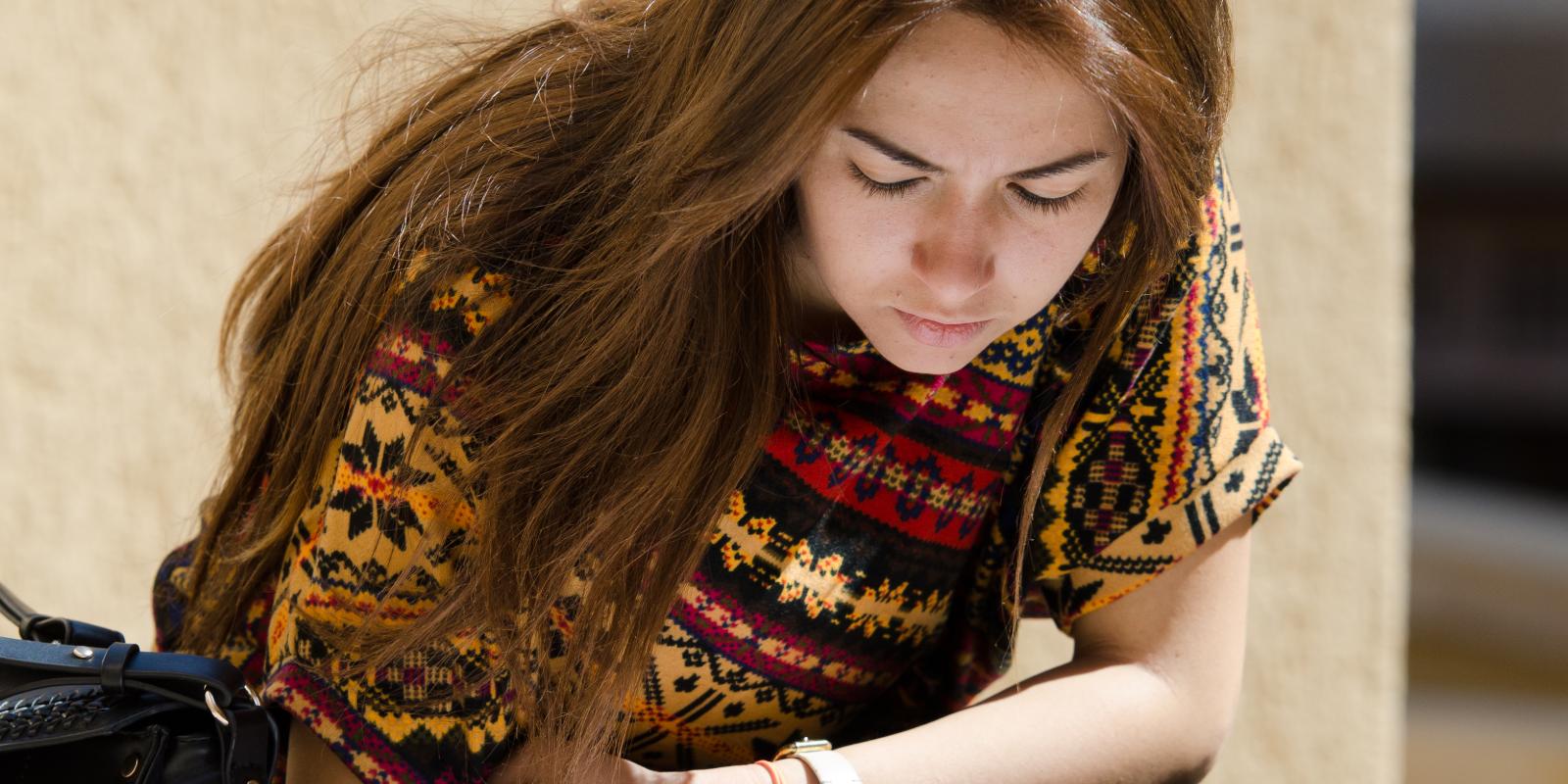 An AUC student writing on campus 