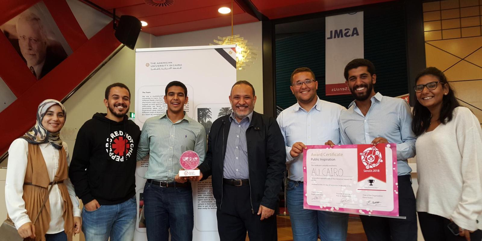 Azzazy (center) with the winning team of AUC students