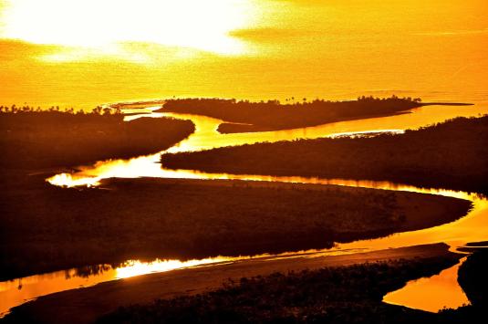 Sun shining over a river, representing global warming and climate change