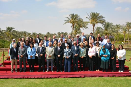 A photo of the attendees of the Senate 30th anniversary celebration, standing on a red carpet in the AUC Garden.