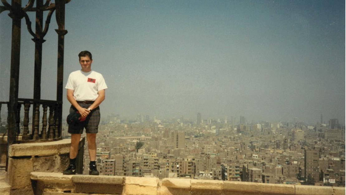 a man dressed in a tshirt and shorts standing on top of a building