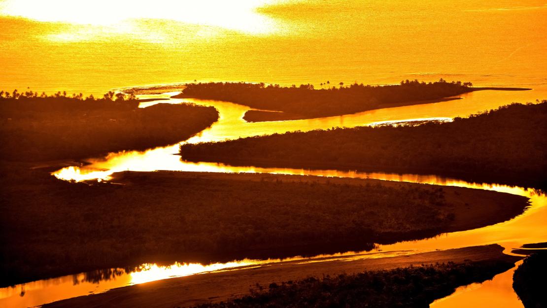 Sun shining over a river, representing global warming and climate change