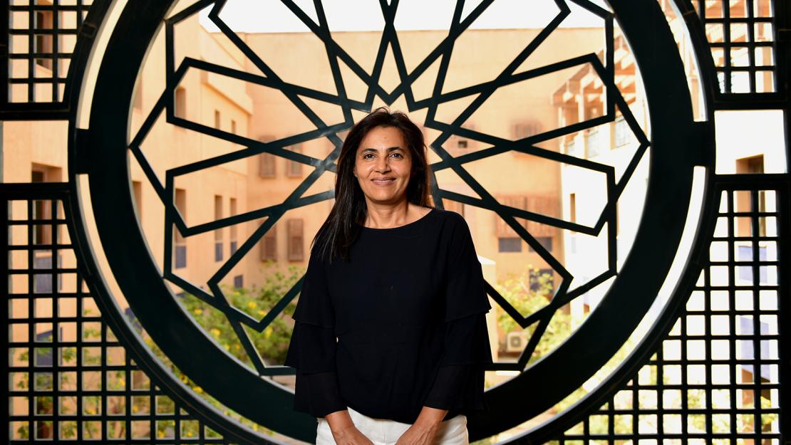 Woman standing in front of a wall with Arabian decor