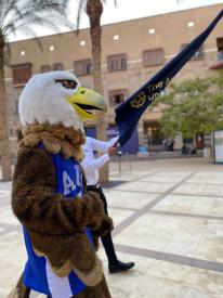 AUC Eagles Mascot Holding Flag