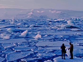 Two people standing on ice