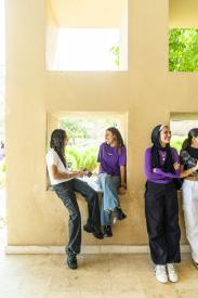 Two girls sitting in a hollow square window smiling