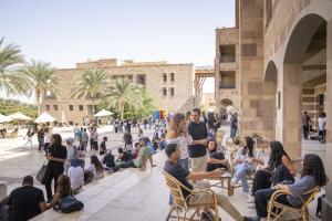 Students sitting under SSE building socializing