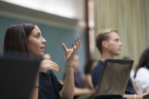 Girl sitting in class answering a question