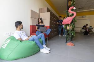 A girl and a boy sitting in a student lounge talking to each other