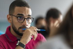 Boy in class wearing glasses and thinking