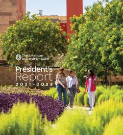 Three female students walking in the garden, text reads "The American University in Cairo" "President's Report 2021-2022