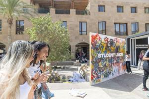 Su sign and girls walking in plaza