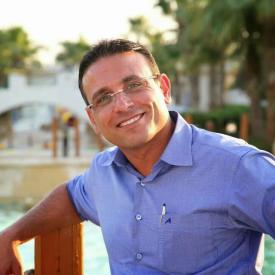 A man smiling and wearing glasses