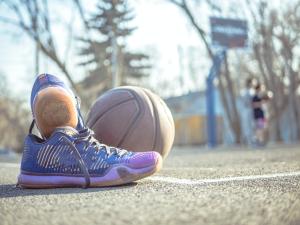 a purple running shoes next to a basketball