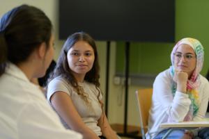 Three girls talking in class