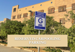 Building with a blue parking sign that reads "Reserved Carpooling Parking"