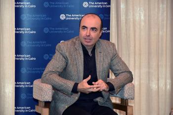 Mohamed Salama sitting on a chair talking to media panelists about his research on healthy aging