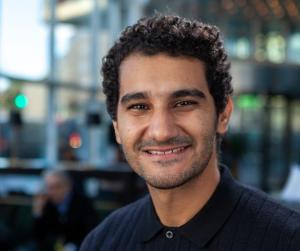 man with black hair smiles at camera