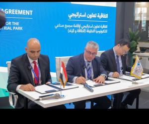 Three men in suits signing paper at a table