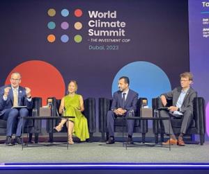 four people sit on a stage having a discussion