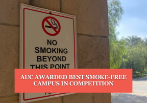 No smoking sign on a wall, text reads "AUC Awarded Best Smoke-Free Campus in Competition"