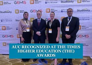 Three men and one woman standing, text reads "AUC Recognized at The Times Higher Education Awards"