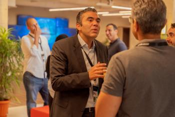 a man in a suit talking to another man in a meeting room