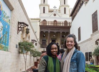 two student in front of hanging church