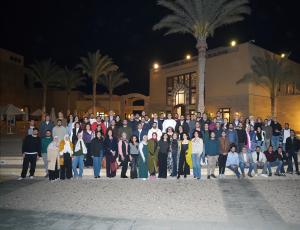 a group photo at the innovation summit taken at night at AUC New Cairo campus