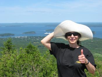 A woman (Deborah Ciresi) is standing in a green field