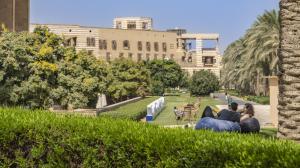 students sitting on a beanbag in the garden overlooking greenery and buildings