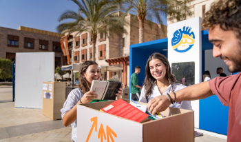 Students pick up books from a box