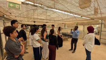 a group of students listening to a faculty member