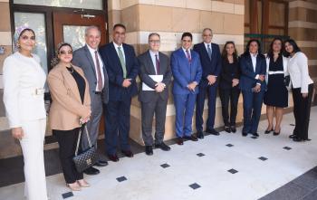 A group of women and men from AUC and Attijariwafa bank Egypt pose for a photo in front of a classroom