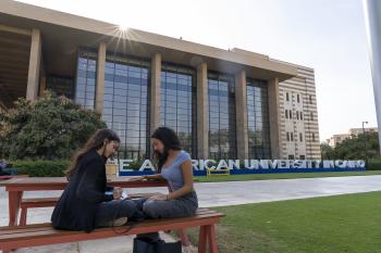 two girls sitting on a bench playing together is the university gardens