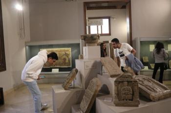 Students bending down and standing in front of Coptic monuments to examine them