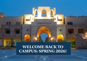 A building that is lit at night. Text: Welcome Back to Campus: Spring 2026!