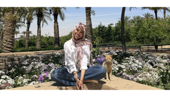 Laila sitting in the AUC gardens with a cat